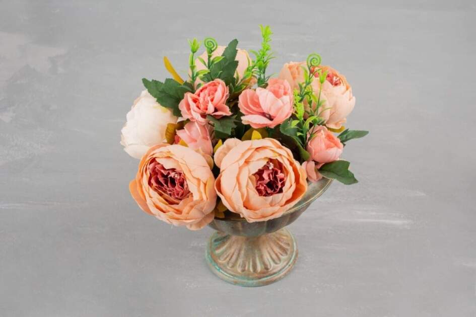 A beautiful flower presentation of pink roses in a stylish vase, placed on a table.